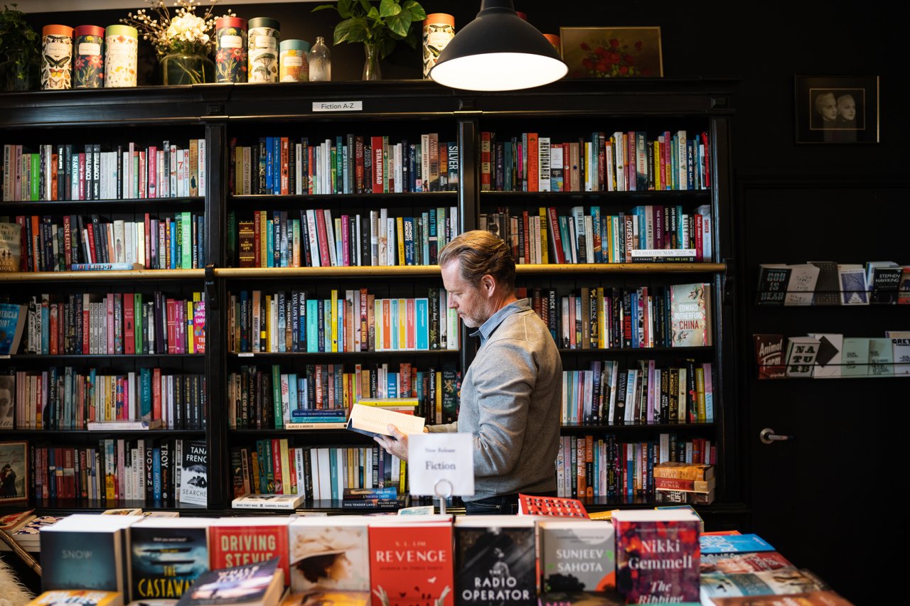 Man reading a book in a book store.