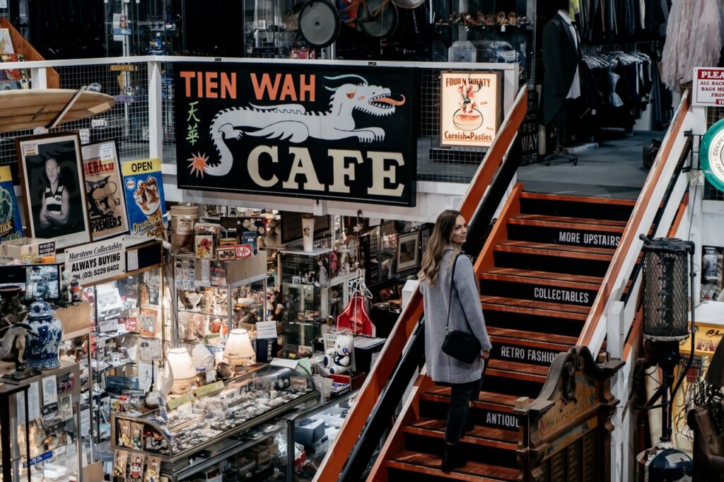 A person walks up stairs to the second mezzanine level inside a vintage store.