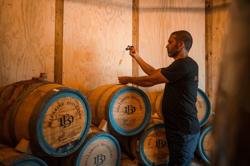 A man samples gin from a cask at Bellarine Distillery.